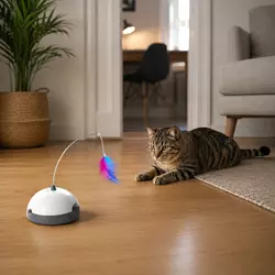 Gato jugando solo con juguete automático interactivo para gatos dentro de casa